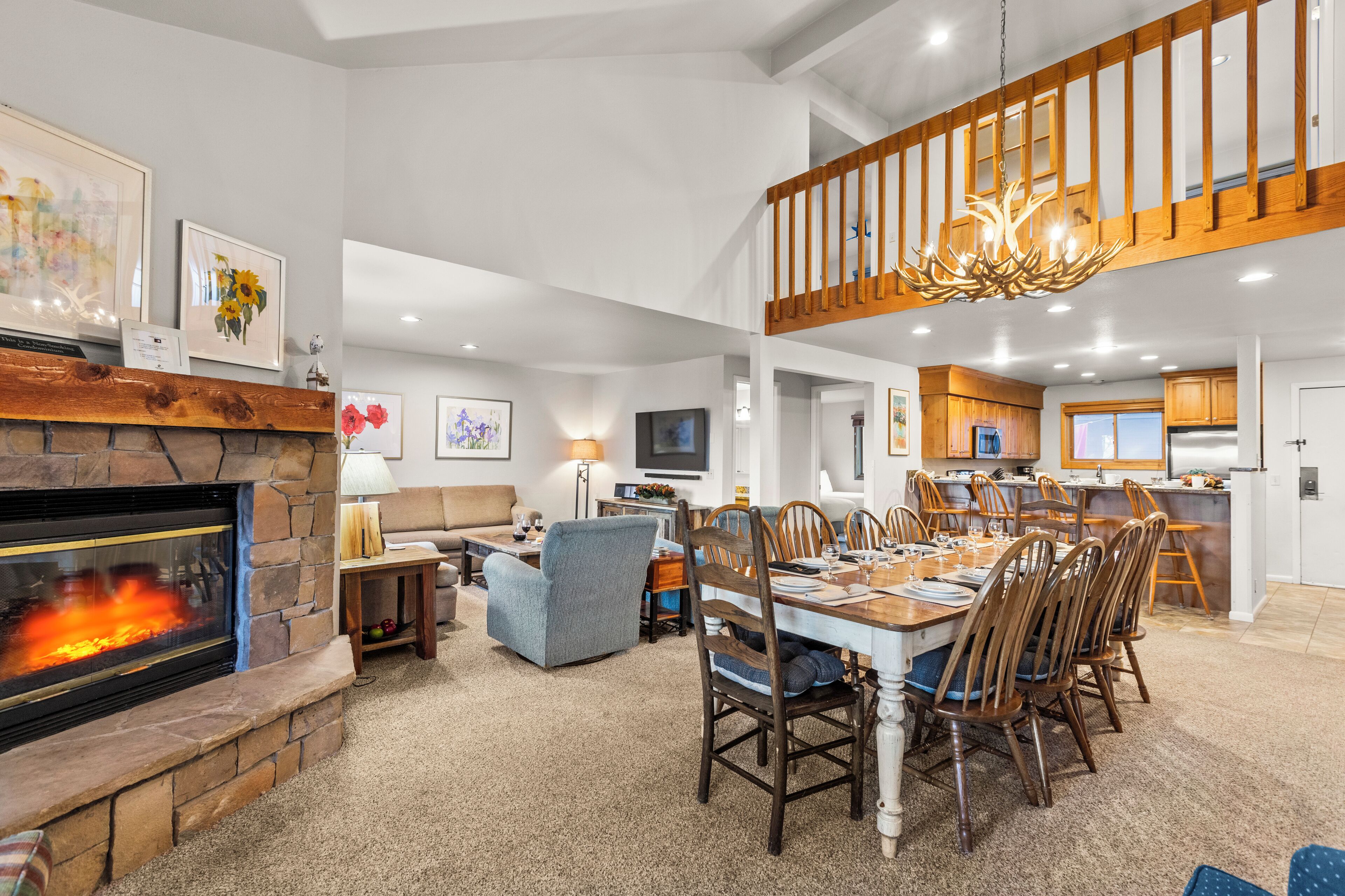 A spacious living room with a fireplace, dining area, and kitchen.