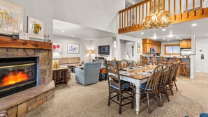 A spacious living room with a fireplace, dining area, and kitchen. - True Ski-In/Ski-Out to Park City Mountain Resort I Managed by Park City Lodging (Park City)