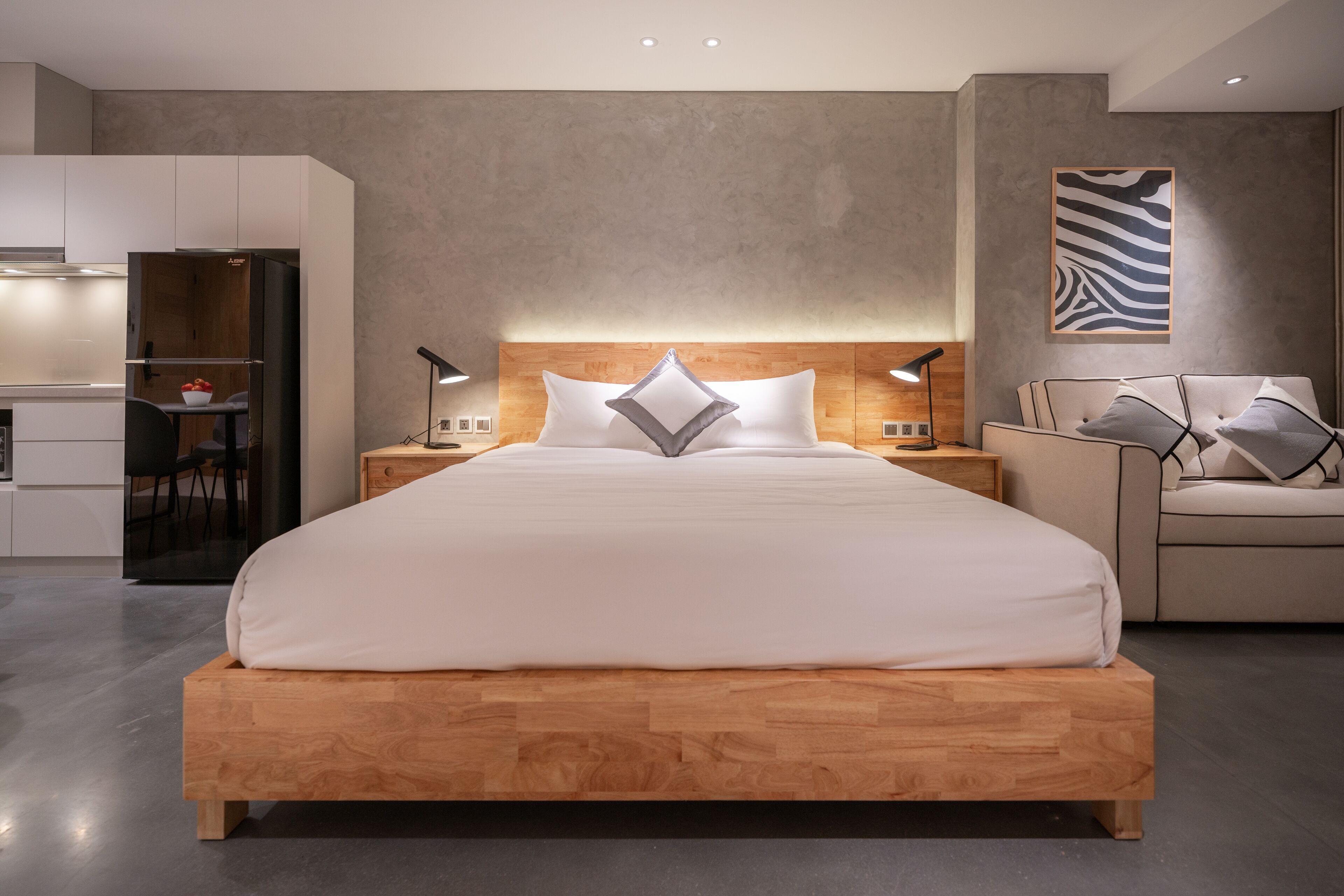 Un dormitorio moderno con una cama de madera, mesitas de noche, un escritorio y una silla.