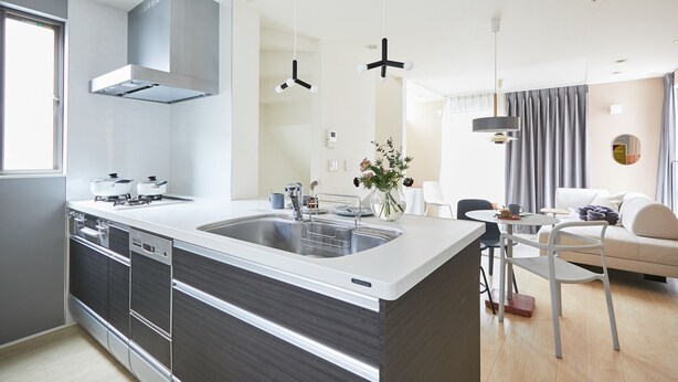 A modern kitchen with a central island, built-in appliances, and a dining area with a table and chairs. - P OIN T Ikebukuro Designer's Villa (Tokyo)