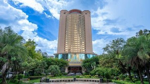 A tall, cylindrical hotel with a central entrance and a glass facade. - Junyi Hotel (Shenzhen)