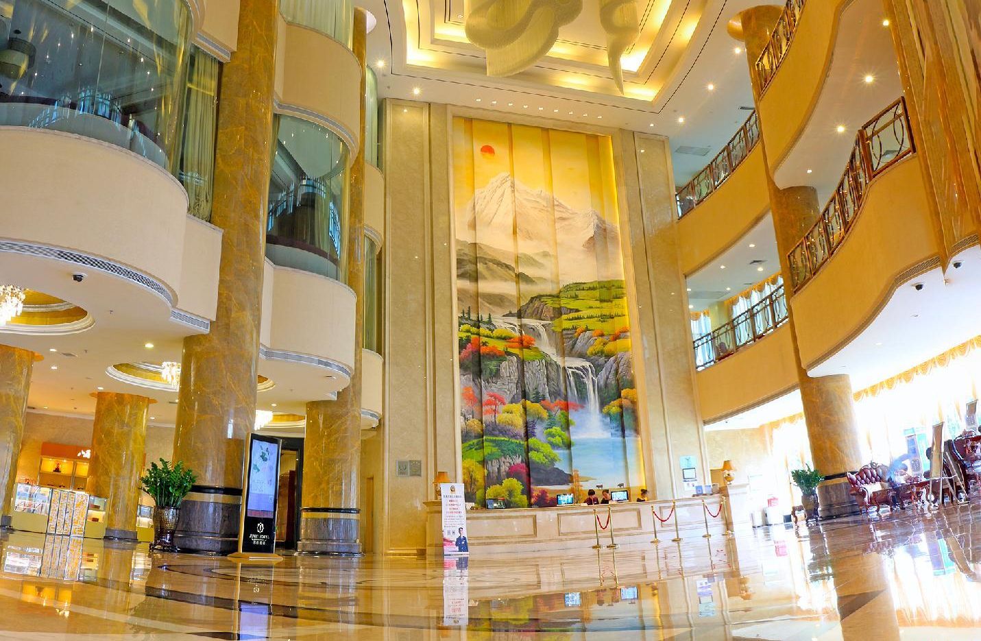 A spacious lobby with a large mural, multiple floors, and a modern design.