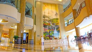 A spacious lobby with a large mural, multiple floors, and a modern design. - Junyi Hotel (Shenzhen)