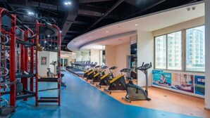 A gym with treadmills, stationary bikes, and a red weightlifting area. - Junyi Hotel (Shenzhen)
