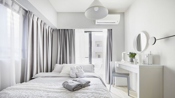 Une chambre d’hôtel moderne, dotée d’un grand lit, d’un bureau et offrant une vue sur la ville.