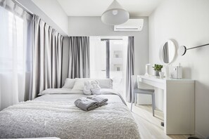 Une chambre d’hôtel moderne, dotée d’un grand lit, d’un bureau et offrant une vue sur la ville.
