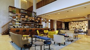 A modern lobby with a bar area, seating arrangements, and a staircase. - Rotterdam Marriott Hotel (Rotterdam)