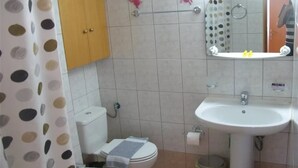 Een badkamer met toilet, wastafel en spiegel.