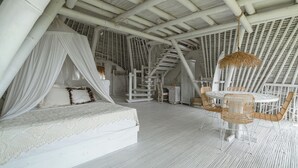 Una habitación amplia y luminosa, con una cama, una mesa de comedor y sillas.