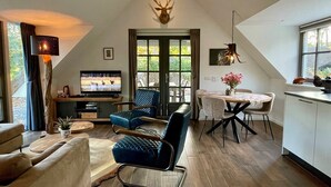 Ein gemütliches Wohnzimmer mit Kamin, Fernseher und Essbereich mit Tisch und Stühlen.