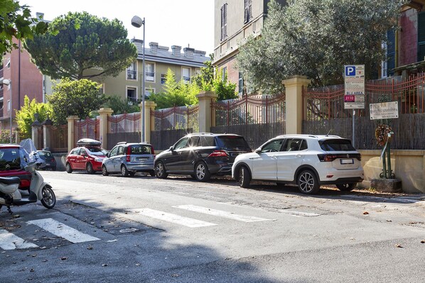 Een straat met geparkeerde auto's en een voetgangersoversteek.