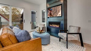 A modern living room with a fireplace, a sofa, a chair, and a coffee table. - Abode on Cloud 9, private hot tub, Old Town retreat, groups (Park City)