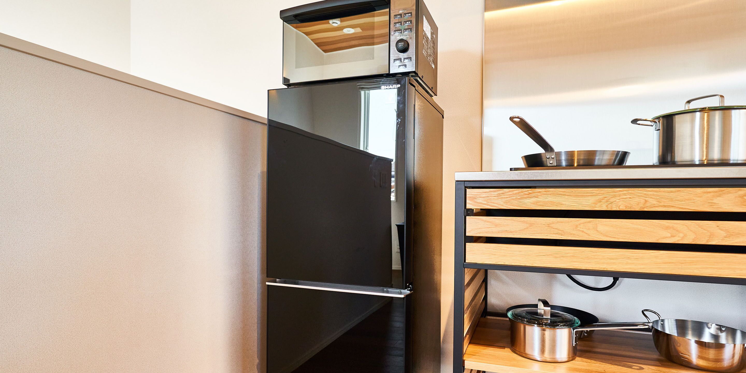 Una cucina moderna con frigorifero integrato, forno a microonde e mobili in legno.