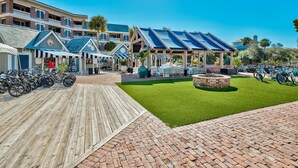 Ein Strandhotel mit mehrstöckigen Gebäuden, Außenbereichen zum Sitzen und einem Bereich für Fahrradstellplätze.
