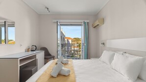 A hotel room with a bed, a desk, a chair, and a balcony with a view. - Eleana Hotel by GHH (Zakynthos)