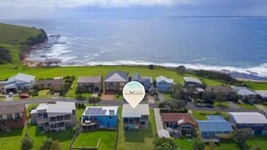 A coastal residential area with houses, a road, and a view of the sea. - Cool View - Views of Seven Mile Beach (Gerroa)