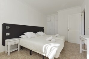 Une chambre à coucher comprenant un lit, une table de chevet, une armoire et un bureau.