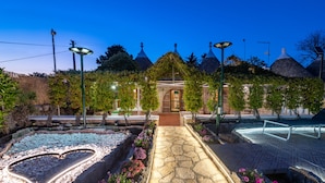 A garden pathway with a heart-shaped water feature, stone tiles, and a gazebo.