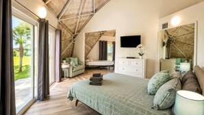 A bedroom with a large bed, a TV, a dresser, and a window with curtains. - STUDIO 05 - Lake Sumner (Clermont)