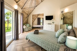 A bedroom with a large bed, a TV, a dresser, and a window with curtains. - STUDIO 05 - Lake Sumner (Clermont)