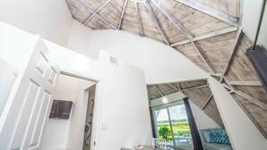 An interior with a sloped ceiling, a door leading to a balcony, and a seating area with a view. - STUDIO 05 - Lake Sumner (Clermont)