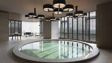 Una piscina techada, sillones reclinables de piscina