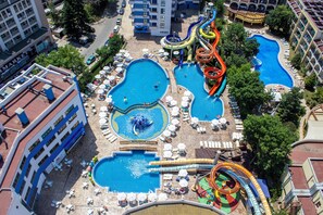Un hotel con varias piscinas, toboganes acuáticos y tumbonas.