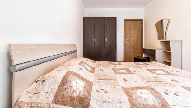 Une chambre à coucher avec un lit, une armoire et un miroir.
