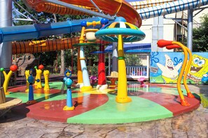 A water play area with colorful structures and a SpongeBob SquarePants mural.