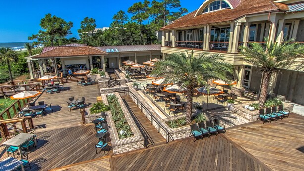 A wooden deck with outdoor seating, palm trees, and a view of the ocean. - New Inventory! Updated Kitchens and Baths 2 BR Bikes & Beach Gear included (Hilton Head Island)