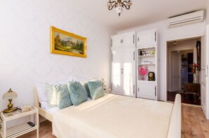 A bedroom with a bed, white wardrobe, and a painting on the wall. - Holiday Home Avantgarde (Dubrovnik)