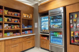 Una cocina con armarios de madera, un refrigerador y un congelador llenos de aperitivos y bebidas.