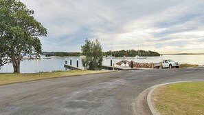 A marina with a dock, a white vehicle, and a tree.