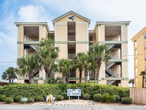 A multi-story hotel with balconies, palm trees, and a sign indicating it is a Blue Dolphin hotel. - Blue Dolphin 403 Penthouse (Fort Walton Beach)