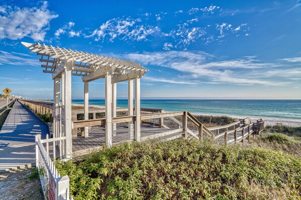 A wooden beach structure with a covered walkway and a view of the ocean.
