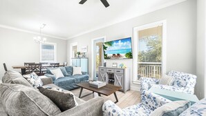 A living room with a sofa, armchairs, a coffee table, and a TV. - Sandy Toes Gated Community*Pool*Gym*Beach Svc! (Miramar Beach)
