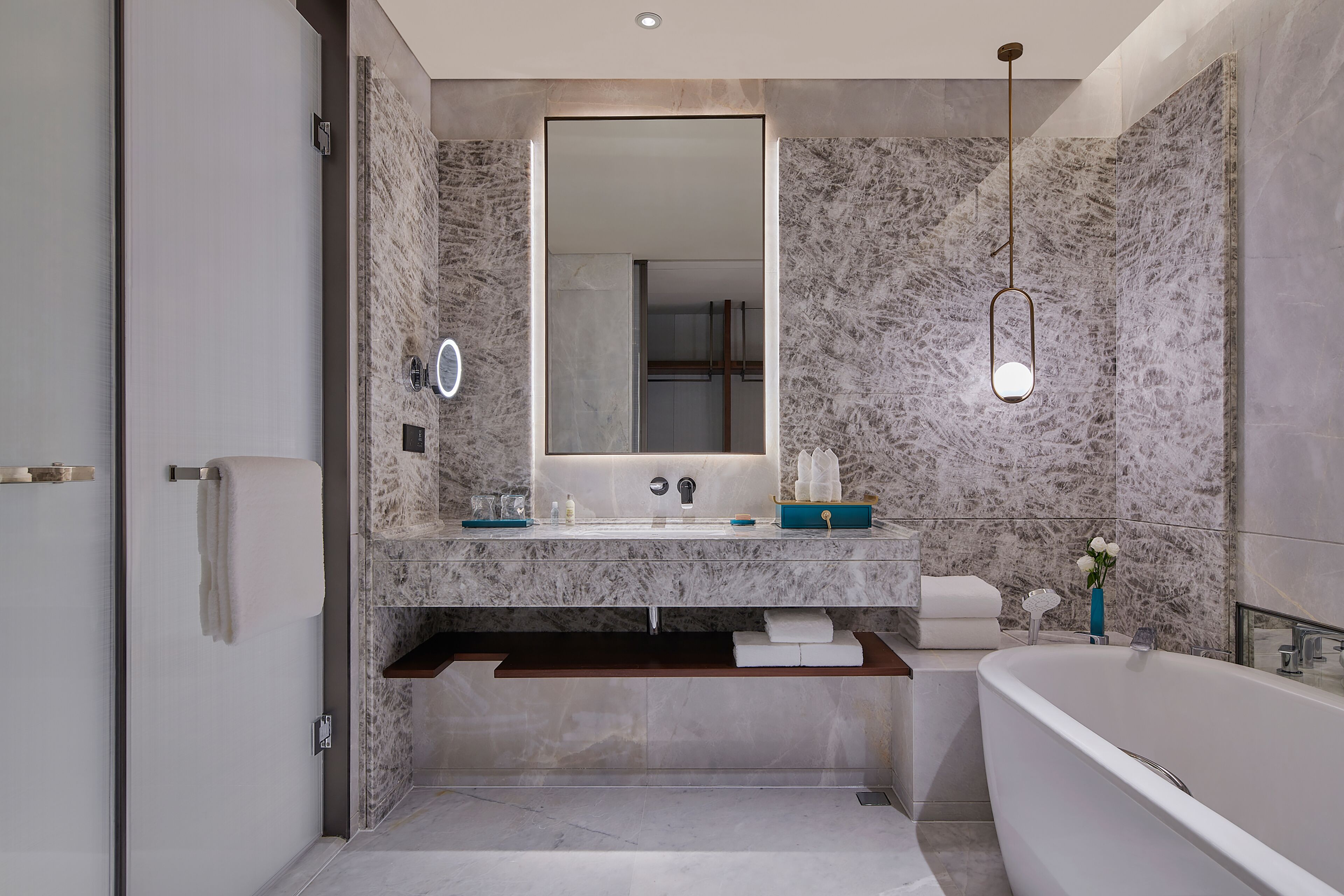 Een aparte badkuip en douche, een regendouche, designer toiletartikelen
