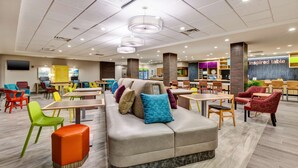 Un vaste espace intérieur aménagé avec différents types de sièges, notamment des canapés, des fauteuils et des tables.