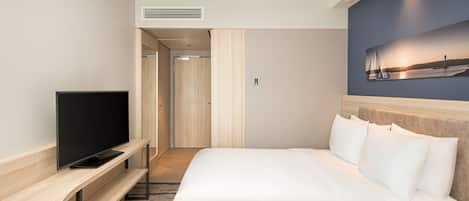 Quarto de hotel com uma cama, uma televisão em um suporte de madeira, um quadro na parede e uma porta que dá para um corredor.