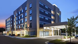 A modern hotel with a flat roof, multiple floors, and a covered entrance area. - Home2 Suites by Hilton Raleigh North I-540 (Raleigh)
