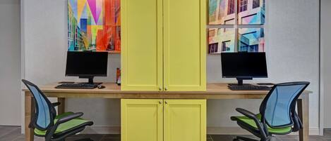 A workspace with two desks, two chairs, and a yellow cabinet.