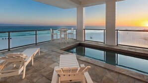 Un espace piscine avec des chaises longues et vue sur l’océan.