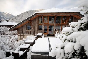 A wooden chalet with a balcony, surrounded by snow-covered trees and mountains. - Chalet Abbaye (Saint-Jean-d'Aulps)
