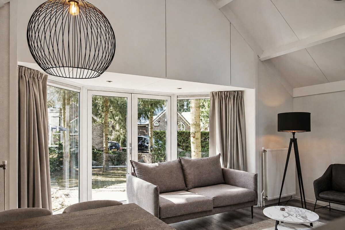 Un salon moderne avec un canapé, une table basse et un lampadaire.