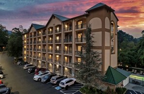 A multi-story hotel with a parking lot in front. - Downtown Gatlinburg Luxury Penthouse, Mountain Views & 2 Balconies (Gatlinburg)