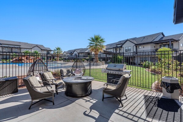 A patio area with outdoor furniture, a grill, and a view of a swimming pool and houses in the background. - Ocotillo Springs Resort #67Private Pool, Hot Tub, Ping Pong and Community Amenities (Santa Clara)