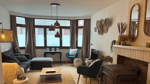 En hyggelig stue med pejs, sofa, sofabord og tv.