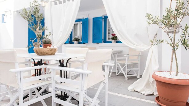 An outdoor seating area with white furniture and terracotta pots.