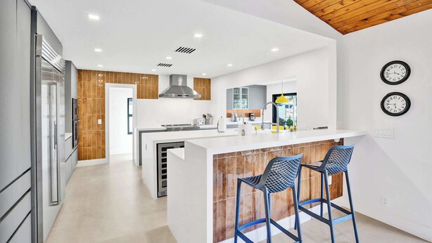 A modern kitchen with a central island, stainless steel appliances, and a wooden ceiling. - Villa by the Sea🌴  🌊  Luxury Coastal Retreat - 5 Minute walk to beach (Lauderdale by the Sea)