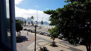 A street view with a crosswalk, parked cars, and a tree. - TC202 Paraíso na Praia (Rio de Janeiro)